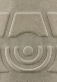 Strukturstoff in einem hellbeigen Farbton mit erhöhten geometrischen Formen, darunter ein Bogen und zirkuläre Details, die feine Webmuster präsentieren.