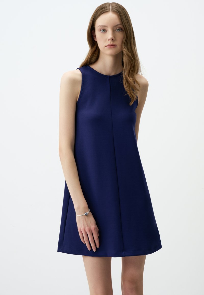 Marineblaues ärmelloses Kleid mit rundem Ausschnitt und A-Linien-Silhouette, ausgestattet mit einer zentralen Naht und einer glatten, weichen Stofftextur.