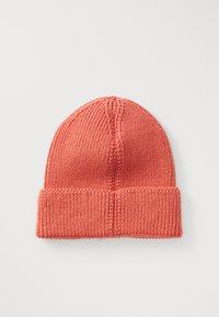 Coral-colored knitted beanie hat with folded brim, displayed flat on a white background.