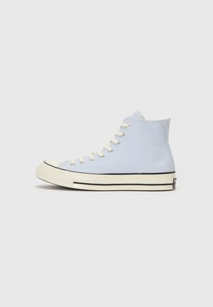 High-top sneakers with a light blue canvas upper, white rubber sole, and black accent stripe along the bottom edge. White laces.