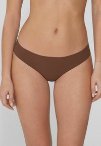 Brązowe bikini dolne o gładkiej fakturze, z minimalistycznym wzornictwem i niskim stanem. Regulowane i bezszwowe brzegi.