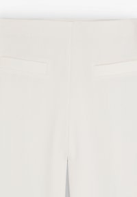 Pantalon beige clair en tissu lisse, avec une coupe droite, deux poches arrière et des détails de couture minimaux.