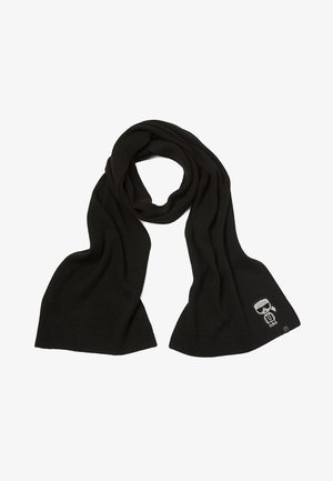 Écharpe en maille noire avec un centre bouclé et un petit écusson représentant un personnage de dessin animé portant des lunettes de soleil à une extrémité, présentée sur fond blanc.