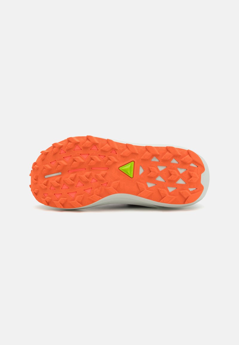 Suola di una scarpa con una superficie in gomma arancione testurizzata, caratterizzata da lugs triangolari, accenti bianchi e un dettaglio triangolare verde.