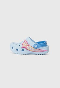 Sabot bleu clair avec motif d'étoiles et rayures multicolores. Fabriqué en plastique, comportant des trous de ventilation et un logo circulaire bleu sur le côté.