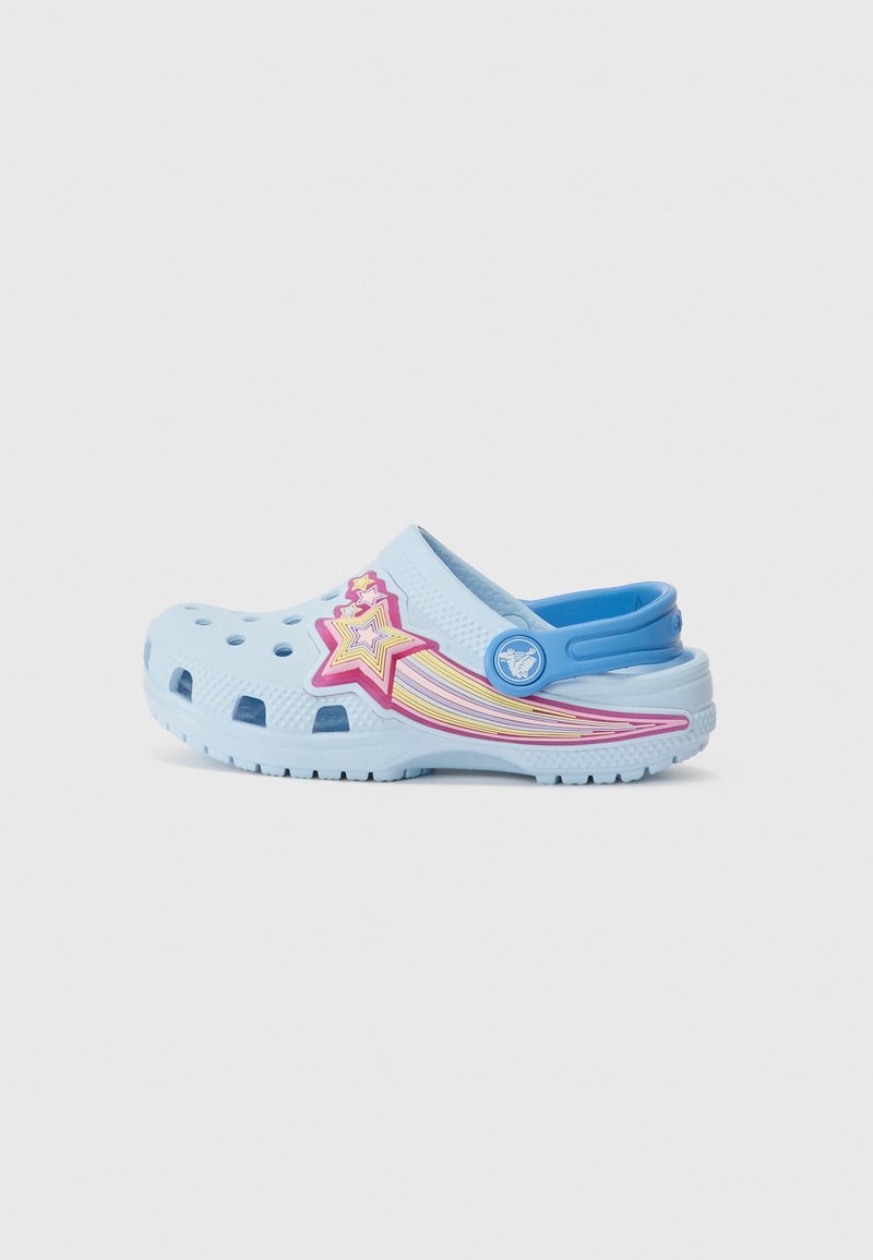 Sabot bleu clair avec motif d'étoiles et rayures multicolores. Fabriqué en plastique, comportant des trous de ventilation et un logo circulaire bleu sur le côté.