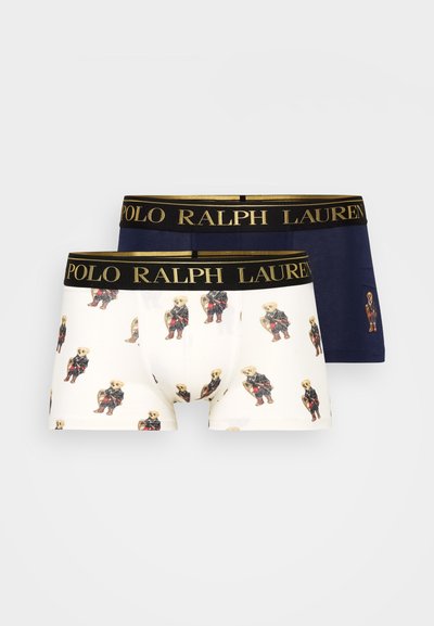 Dvoje boxeriek: jedny biele so vzorom medveďov, druhé jednofarebné námorníckomodré. Obe majú čierny pás s nápisom "POLO RALPH LAUREN" v zlatej farbe.