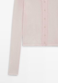 Cardigan court rose pâle, à manches longues, col en V, avec six boutons assortis sur le devant. Tissu doux et texturé.