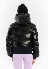 Zwarte pufferjack met een glanzende afwerking, capuchon en elastische tailleband. Heeft een cropped ontwerp en zichtbare stiksels.