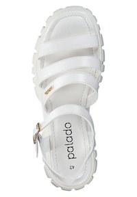 Valkoinen hihnallinen sandaali, jossa on paksu pohja, säädettävä solki ja kultainen koroste. Tasainen nahkamateriaali, yksinkertainen muotoilu ja pyöreä muoto.