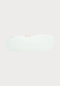 Fehér sneaker talp, texturált tapadó mintával, minimalista dizájnnal és világos színű akcentusokkal az oldalán.
