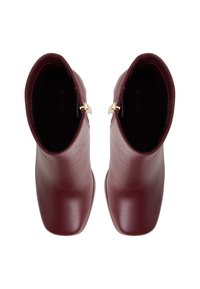 Burgundy leather ankle boots with a smooth finish, square toes, and gold hardware accents at the zippers. Interior branding visible.