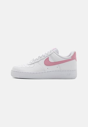 Zapatillas Nike Air Force 1 blancas con detalles en rosa, parte superior de cuero suave, diseño de puntera perforada, cordones planos y suela de goma.