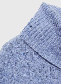 Maglione di colore azzurro chiaro a maglia con colletto a coste, caratterizzato da un motivo testurizzato e piccole macchie blu sparse su tutto il tessuto.