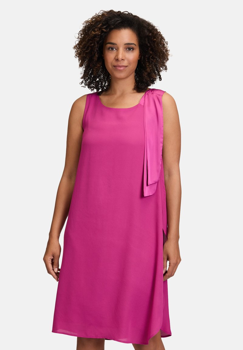 Ärmelloses pinkes Kleid mit lockerer Passform, das mit einem Banddetails an der Schulter, glatter Textur und knielangem Schnitt ausgestattet ist.
