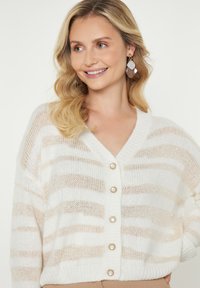 Cardigan lavorato a maglia bianco con strisce orizzontali beige, collo a V e sei bottoni. Tessuto morbido con vestibilità rilassata.