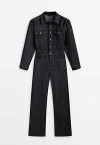 Granatowy dżinsowy kombinezon z długimi rękawami, zapięciem na guziki z przodu, dwiema kieszeniami na klatce piersiowej z klapkami oraz szerokimi nogawkami.