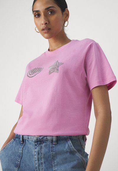 Pink cotton t-shirt with short sleeves, featuring silver stud embellishments in the shape of a swoosh and star on the front.