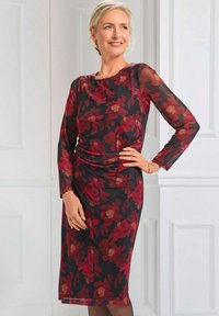 Langärmliges, figurbetontes Kleid mit einem dunklen Hintergrund und großen roten Blumenmustern, hergestellt aus einem transparenten Stoff mit glatter Textur.