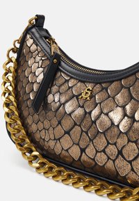 Sac hobo avec un motif écailles bronze métallique, accents en cuir noir, bandoulière en chaîne dorée et fermeture éclair avec un petit logo.
