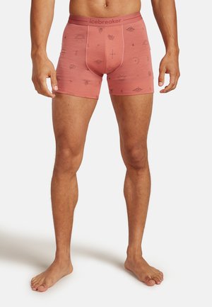 Männerboxershorts in einem hellrosafarbenen Farbton mit schwarzen geometrischen Mustern, aus weichem Stoff gefertigt, mit einem elastischen Bündchen und "icebreaker"-Branding.