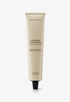 Ceramide hand cream in a beige tube with black nozzle. Features white text labeling and detailing; includes information about ingredients.