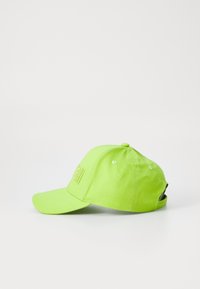 Bright green baseball cap made of cotton, featuring a stitched logo, curved visor, and adjustable strap at the back.