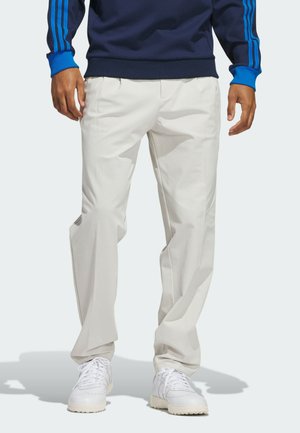 Pantaloni chiari con una vestibilità rilassata, realizzati in tessuto morbido. Abbinati a sneakers bianche. Presentano gambe dritte e una vita strutturata.