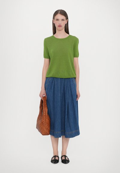 Groene T-shirt trui met korte mouwen, denim rok, bruine geweven handtas en zwarte platte schoenen. Eenvoudig ontwerp met een relaxed fit en casual materialen.