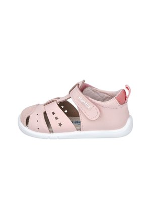 Sandal de cuero rosa con punta cerrada y detalles perforados en forma de estrella. Correa ajustable de velcro, suela blanca y forro de tela para mayor comodidad.