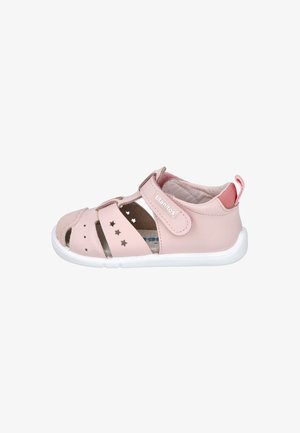 Sandal de cuero rosa con punta cerrada y detalles perforados en forma de estrella. Correa ajustable de velcro, suela blanca y forro de tela para mayor comodidad.