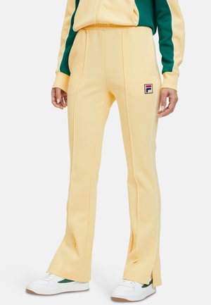 Geel sportbroek met een uitlopende ontwerp, contrasterende witte zijkanten en een klein multikleurig logo op de bovenbeen.