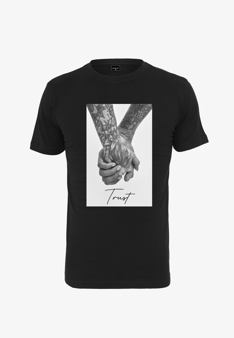 Zwarte T-shirt met een witte foto van twee getatoeëerde handen die elkaar vasthouden, met het woord "Trust" in cursieve letters onder het beeld.