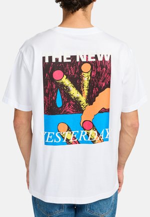 White cotton t-shirt featuring a colorful graphic design on the back with bold text "THE NEW YESTERDAY" and vibrant abstract shapes.