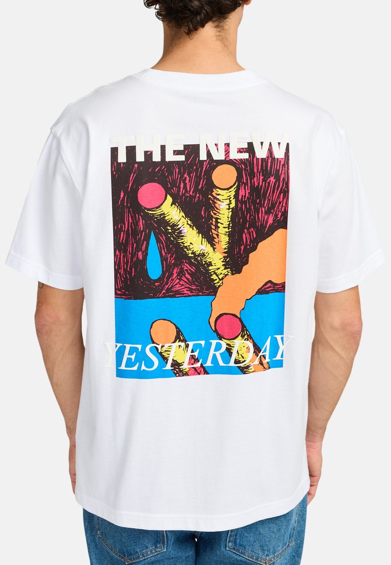 White cotton t-shirt featuring a colorful graphic design on the back with bold text "THE NEW YESTERDAY" and vibrant abstract shapes.
