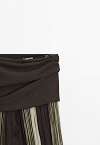 High-waisted pleated skirt with wide dark waistband and vertical stripes in shades of brown, beige, and olive green.