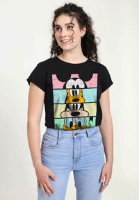 Černé bavlněné tričko s grafikou kreslených postaviček Goofyho, Kačera Donalda a Mickey Mouse v pastelových horizontálních pruzích. Krátké rukávy.