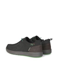 Sneaker in suede nero e marrone con dettagli verdi, forma arrotondata, superficie texturizzata e suole in gomma. Presentano un sistema di allacciatura e linguette per il trasporto.