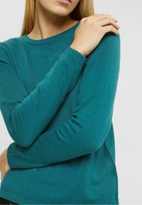 Teal farbener Pullover mit langen Ärmeln und Rundhalsausschnitt, gerippten Bündchen und weicher Textur. Verfügt über eng anliegende Ärmel und eine lockere Silhouette.