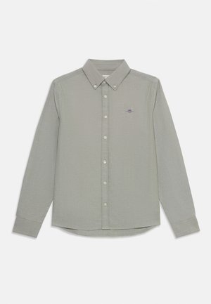 Lichtgroen shirt met lange mouwen, knoopsluiting en knoopjes aan de voorkant; voorzien van een geborduurd logo op de linkerborst. Gemêleerd stof.