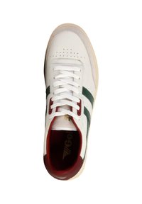 Witte sneaker met groene zijkanten, rode accenten rond de kraag en veters, witte veters en een beige zool, bekeken van bovenaf.