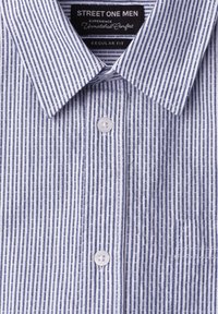 Chemise homme regular fit à boutons avec motif rayures verticales bleu et blanc et col pointu, avec une étiquette de marque à l'intérieur du col.