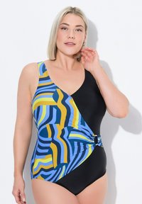 Maillot de bain avec un design à une épaule, motifs de vagues colorées bleu et jaune, et un côté noir avec un accent circulaire à la taille.