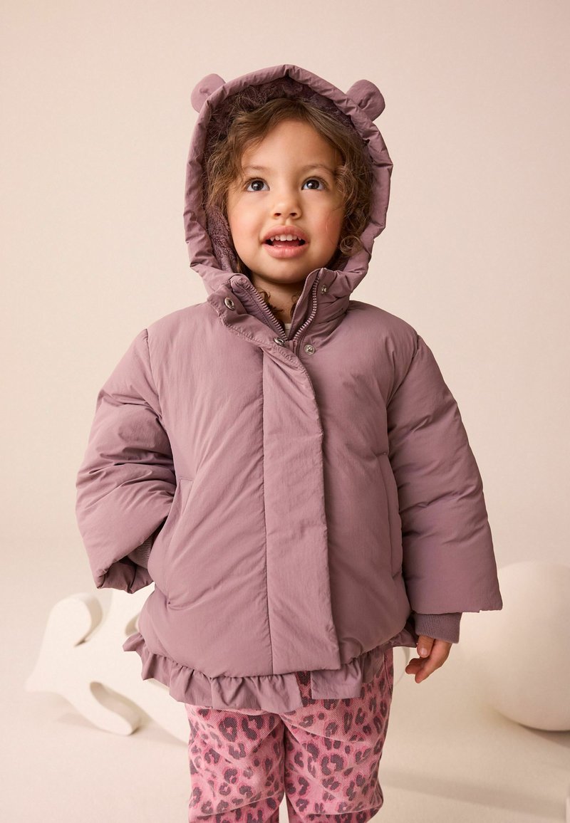 Pink puffer jacket with bear ears, featuring a ruffled hem and snap closure. Worn over pink leopard print pajama pants.