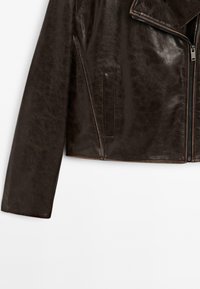 Braune, kurze Lederjacke mit glatter Textur, schlanker Passform und Reverskragen. Mit Reißverschluss vorne und Seitentaschen.