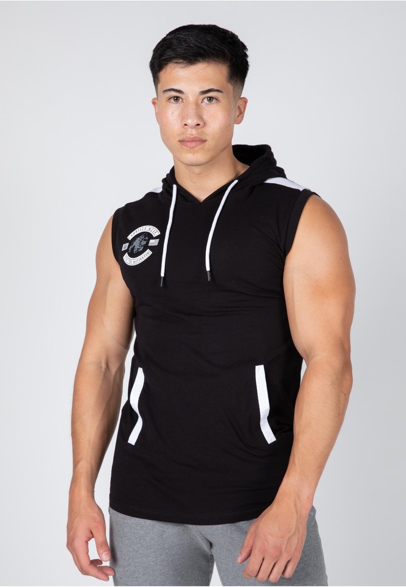 Black sleeveless hooded top made of cotton, featuring white accents on pockets and a circular logo on the chest. Fitted design.