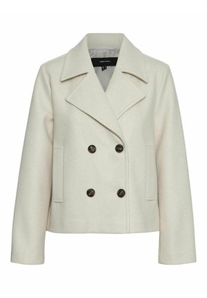 Veste beige croisée à revers, fabriquée en tissu doux, avec deux poches latérales et des boutons foncés comme accents.