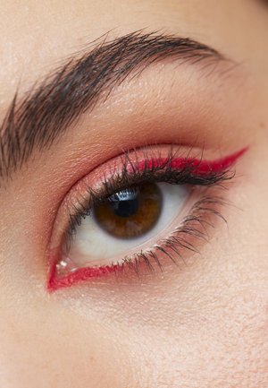 Gros plan sur un œil avec une iris marron, des cils noirs et un eyeliner rouge accentuant la paupière supérieure, complété par des ombres à paupières rose clair.