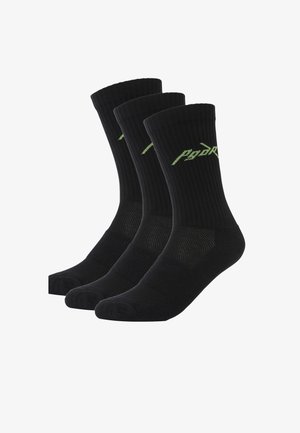 Chaussettes noires à texture côtelée, avec un bout et un talon renforcés, et un logo vert sur la partie supérieure. Vendues par lot de trois.