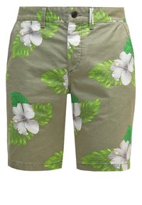 Shorts kaki avec motif de fleurs d'hibiscus blanches et feuilles tropicales vertes, bouton avant et passants de ceinture visibles.